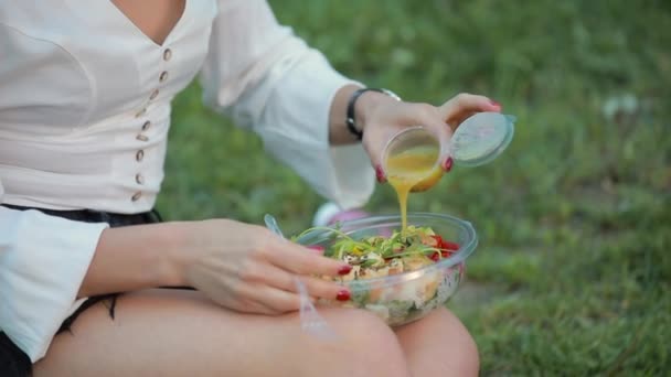 Vrouw giet saus in salade — Stockvideo