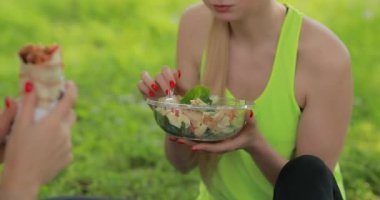 Fitness kadınlar bir parkta taze salata yeme, sağlıklı vejetaryen gıda