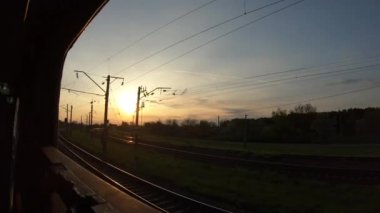 Hareket halinde gün batımı gökyüzü, tren penceresinden görünümü