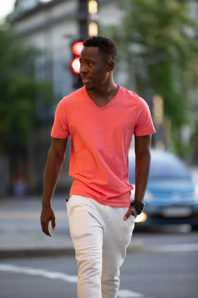 Africano americano em viver coral t-shirt andando na cidade — Fotografia de Stock