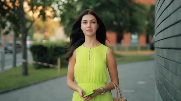 Mulher de vestido verde andando no centro da cidade — Vídeo de Stock