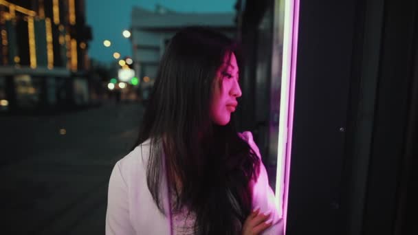 Asiatisk kvinna porträtt på Night City i lila ljus — Stockvideo
