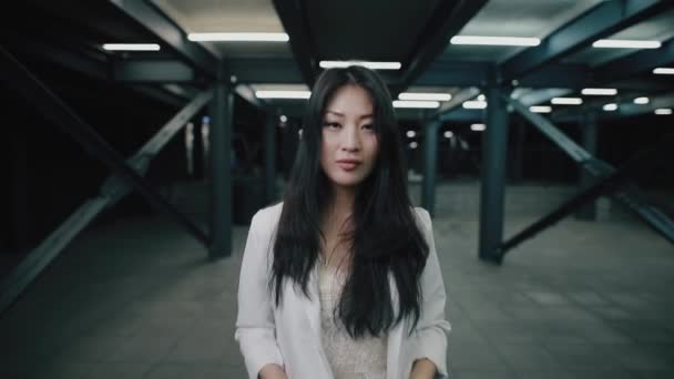 Asiatico donna puts su cuffia walking a notte underground — Video Stock