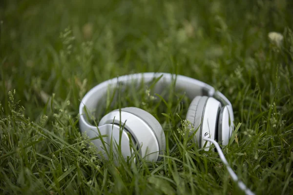 Auriculares blancos en la hierba — Foto de Stock