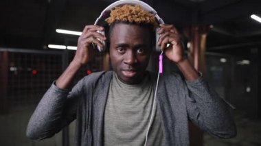 Afrikalı Amerikalı adam gece yeraltı yerde kulaklık giyiyor