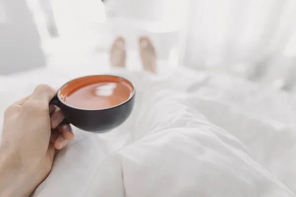 POV, beber chá da manhã na cama — Fotografia de Stock