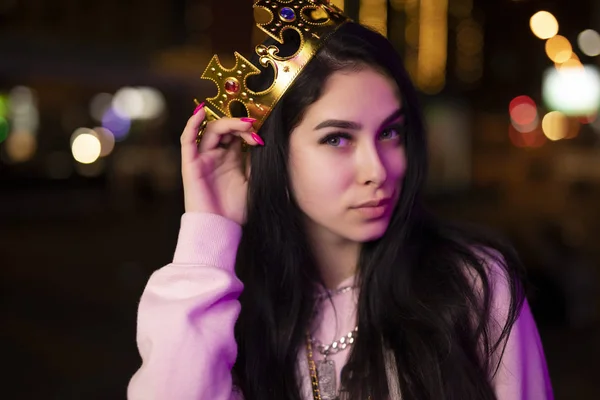 Богатая девушка носит корону в ночном городе — стоковое фото