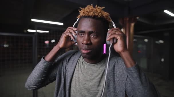 Hombre afroamericano con auriculares en la noche túnel subterráneo — Vídeos de Stock