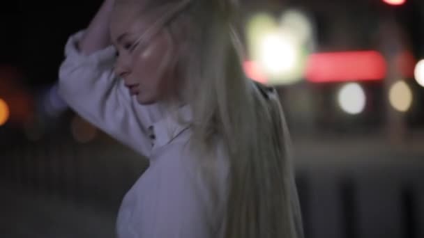 Frau mit langen Haaren verdreht Gesicht in nächtlicher Stadt — Stockvideo