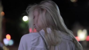 Gece şehirde uzun saçlı seksi kadın yüz açmak