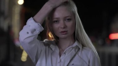 Pretty sarışın model gece şehirde uzun saç dokunmadan poz
