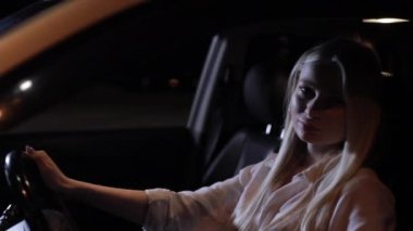 Genç kadın sürücü gece arabada oturuyor