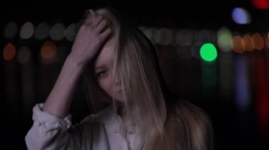 Gece şehirde poz uzun saçlı güzel sarışın model
