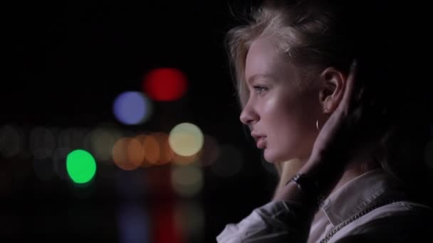 Belle femme blonde toucher ses cheveux longs dans la ville de nuit — Video