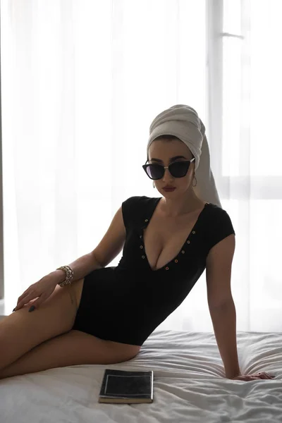 Sexy kvinne med håndkle på hodet leseblad, luksusmorgen – stockfoto