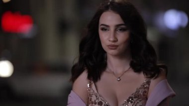 Güzel çekici kadın gece şehirde kamera bakıyor, yavaş hareket