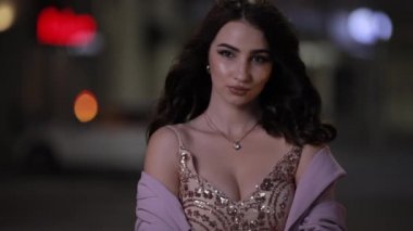 Güzel çekici kadın gece şehirde kamera bakıyor, yavaş hareket