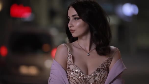 Beautiful attractive woman looking at camera in night city, slow motion — Stock Video