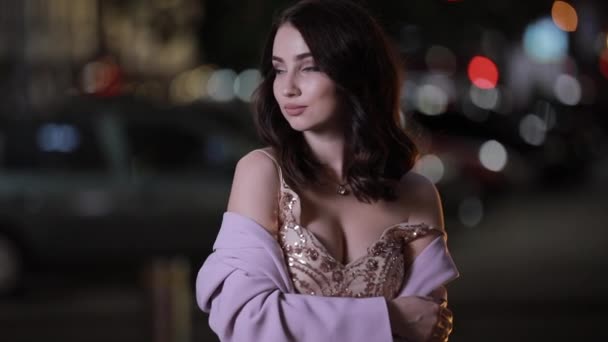 Güzel çekici kadın gece şehirde kamera bakıyor, yavaş hareket — Stok video