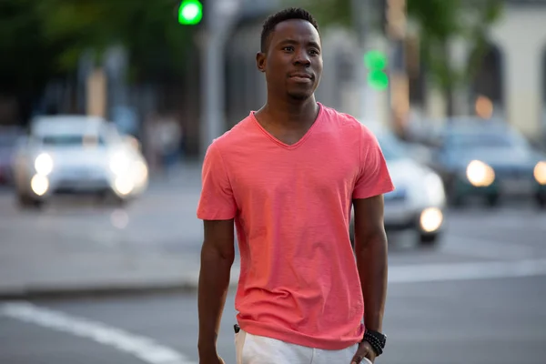 Афроамериканець людина в живих коралових футболку ходити в місто — стокове фото