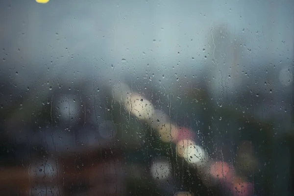 Window with raindrops, blurred background