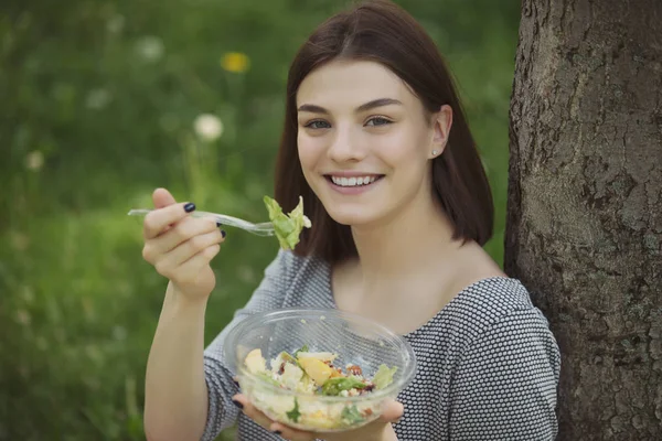 Kvinna äter fräsch sallad sitter på Summer Park — Stockfoto