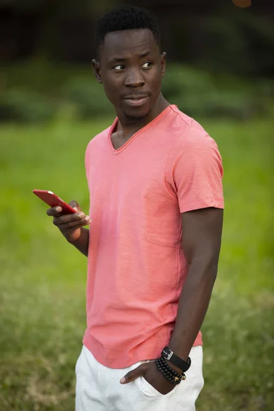 African american man in living coral t-shirt using smartphone