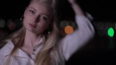 Gece şehirde poz uzun saçlı güzel sarışın model