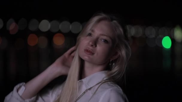 Beautiful blonde model with long hair posing in night city — Stock Video