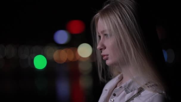 Όμορφη γυναίκα στροφή πρόσωπο στη νύχτα πόλη κοιτάζοντας την κάμερα — Αρχείο Βίντεο