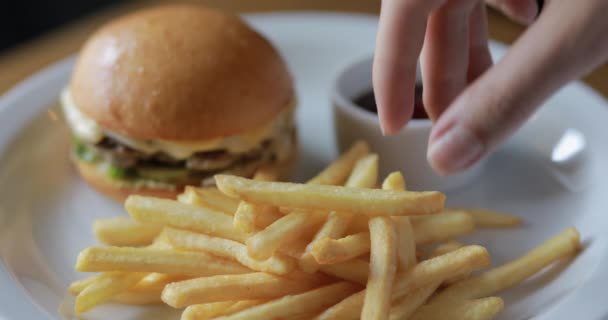 Manger des pommes de terre frites trempant dans la sauce — Video