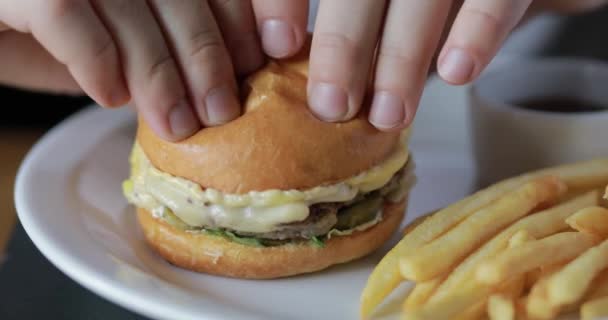 Muerde una hamburguesa de cerca, comida rápida — Vídeos de Stock