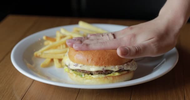 Weibliche Hand schiebt elastischen Burger — Stockvideo