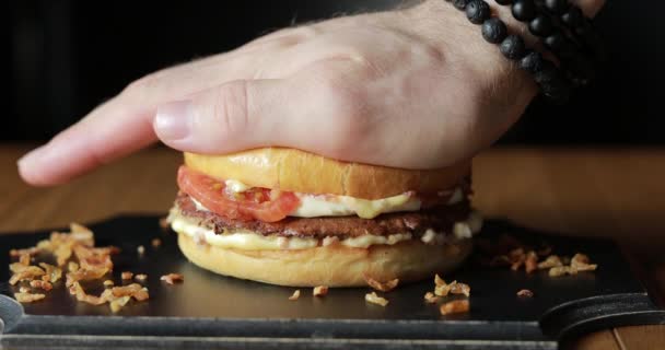 Männliche Hand schiebt elastischen Burger — Stockvideo