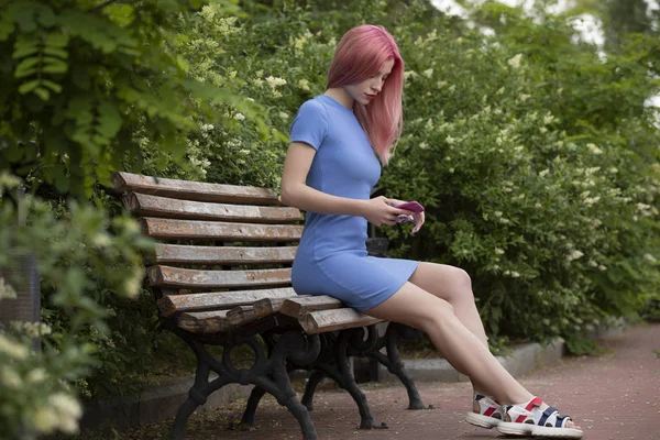 Mulher não convencional com cabelo rosa usando smartphone no banco — Fotografia de Stock