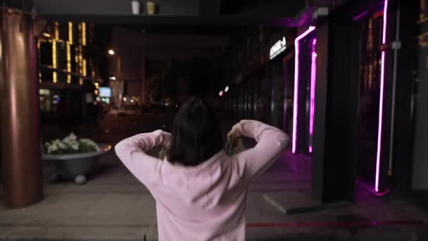 Rich oigenkännlig flicka kastar pengar på Night City — Stockvideo