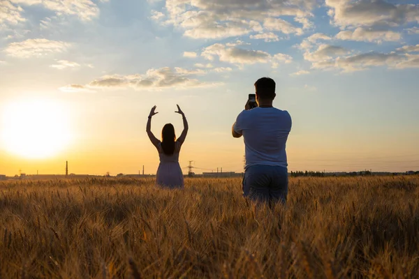 Mann fotografiert Mädchen auf einem Feld — Stockfoto