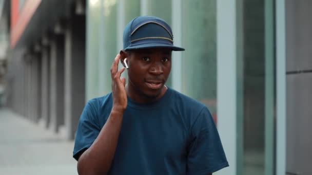 Αφρικανός άνθρωπος αγγίζοντας ασύρματα ακουστικά για την επιλογή μουσικής — Αρχείο Βίντεο