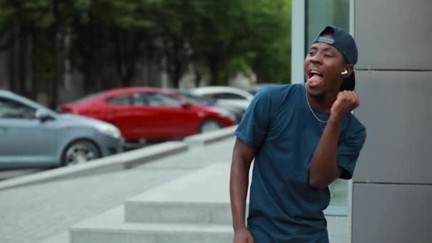 Hombre africano feliz bailando en la ciudad escuchando música en auriculares — Vídeos de Stock