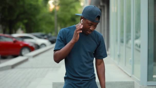 Hombre africano haga clic en auriculares inalámbricos para música de elección — Vídeos de Stock