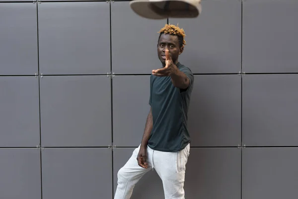Африканский мужчина бросает шапку — стоковое фото