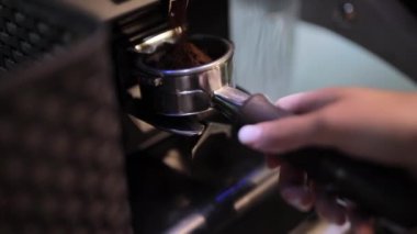 Kahve öğütücü bir filtre tutucu içine kahve çekirdekleri öğütür