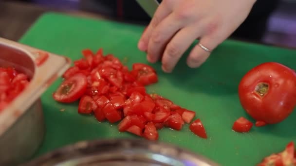 As mãos de chefe cortam o tomate em uma tábua — Vídeo de Stock