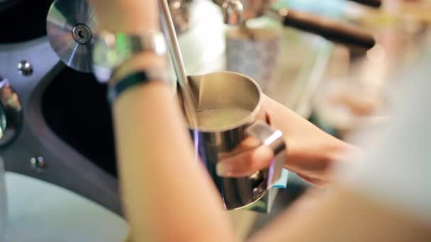 Barista vertiendo leche caliente en una taza de acero — Vídeos de Stock