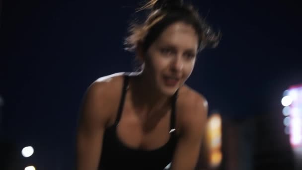 Deporte mujer rompiendo después de mucho tiempo corriendo en un puente nocturno — Vídeos de Stock