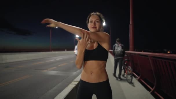 Deporte mujer calentando en la noche ciudad antes de trotar — Vídeo de stock