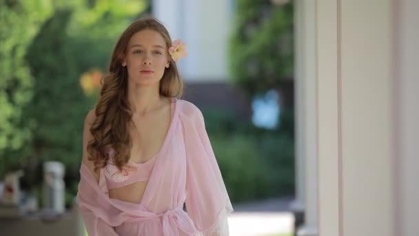 Hermosa modelo en peignoir caminando a lo largo de patio de lujo — Vídeo de stock