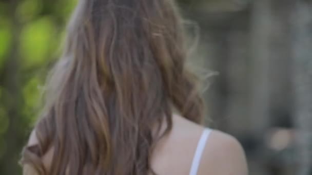 Modèle de mode avec de beaux cheveux en lingerie tournant visage regardant en arrière — Video