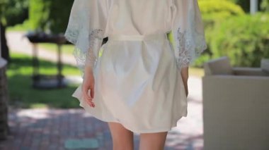 Güzel model içinde Peignoir yürüyüş boyunca ev yard ve dönüm yüz