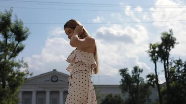 Красива елегантна жінка в сукні, що йде в літньому місті — стокове відео